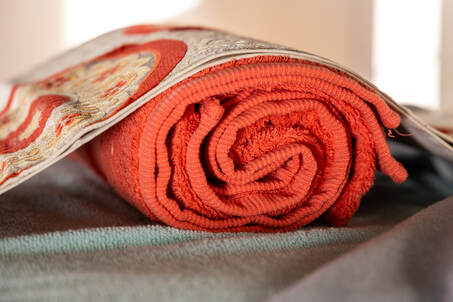 Picture of spa towel on massage table with kimono decoration.