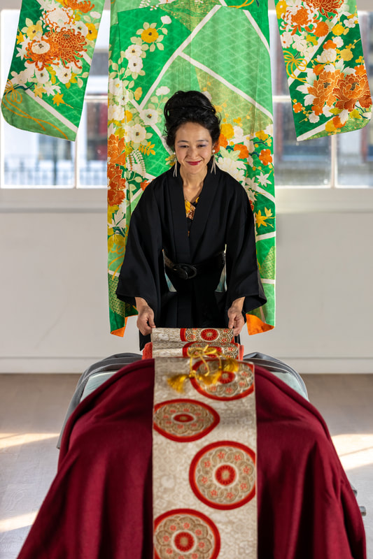 Picture of therapist preparing kimono decoration on massage table.